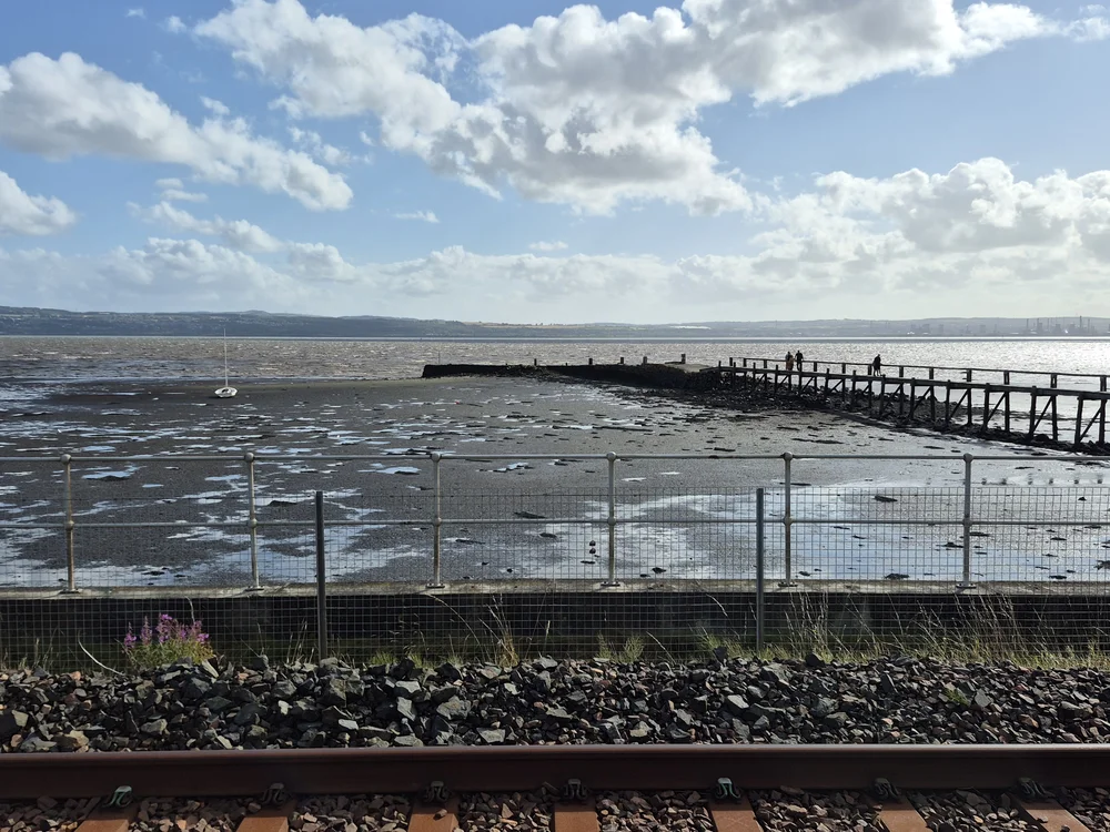 Culross Pier at low water. Small dinghy appears to be moored to the East of the Pier. Seabed appears to be soft in most places.